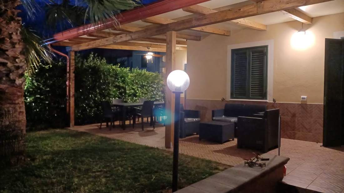 Veranda illuminata la sera con tavolo da pranzo